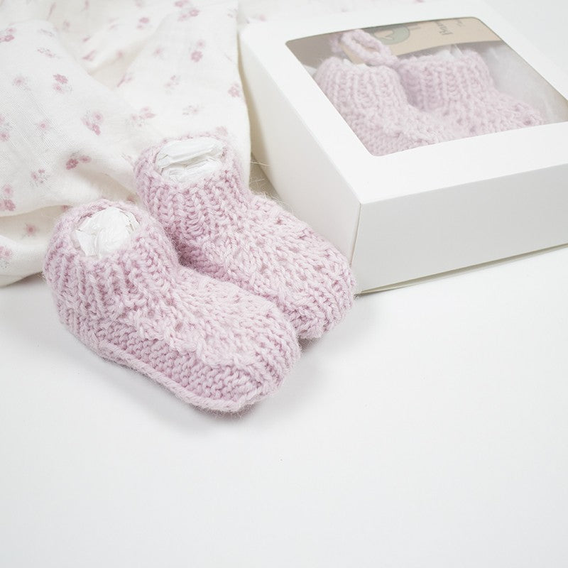 Chaussons coloris rose en tricot avec jours et torsades