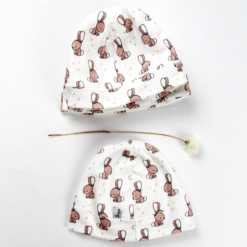 Jolis bonnets bébés parsemés de petits lapins, fabriqués en France.